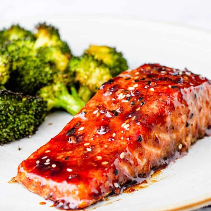 Glazed salmon on a plate with a serving of roasted broccoli.