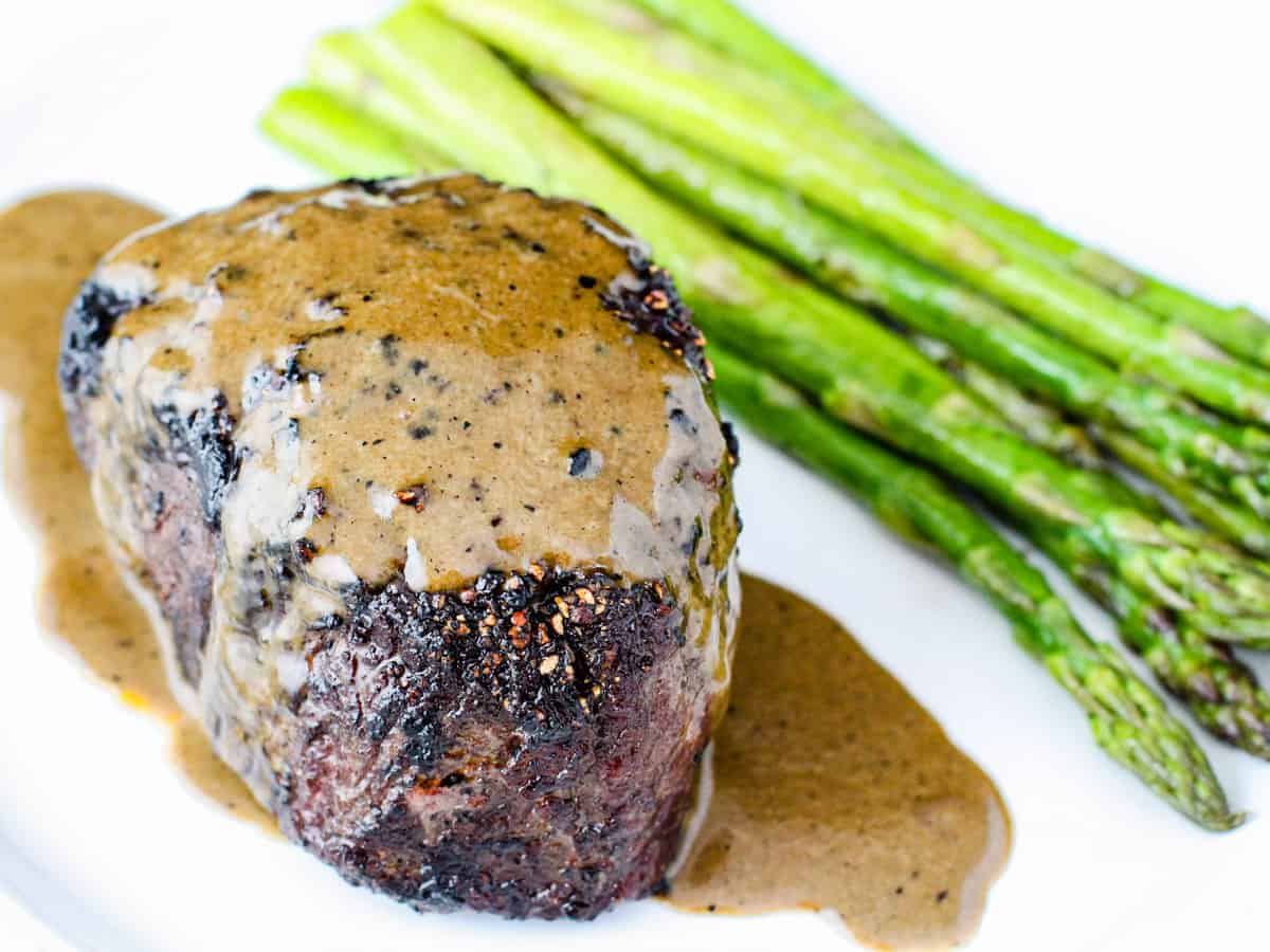 A steak covered with a creamy au poivre sauce.