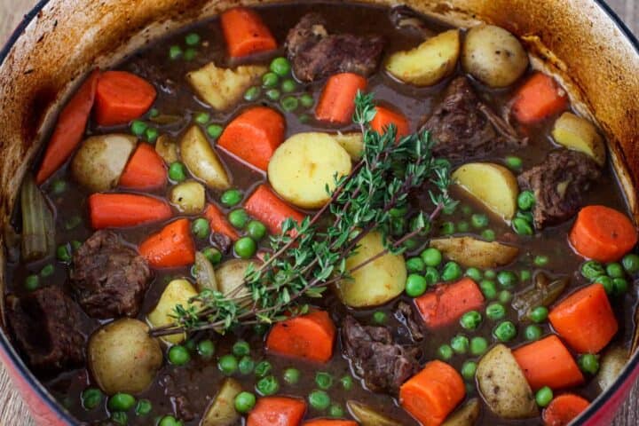 Beef stew cooking in a large dutch oven.