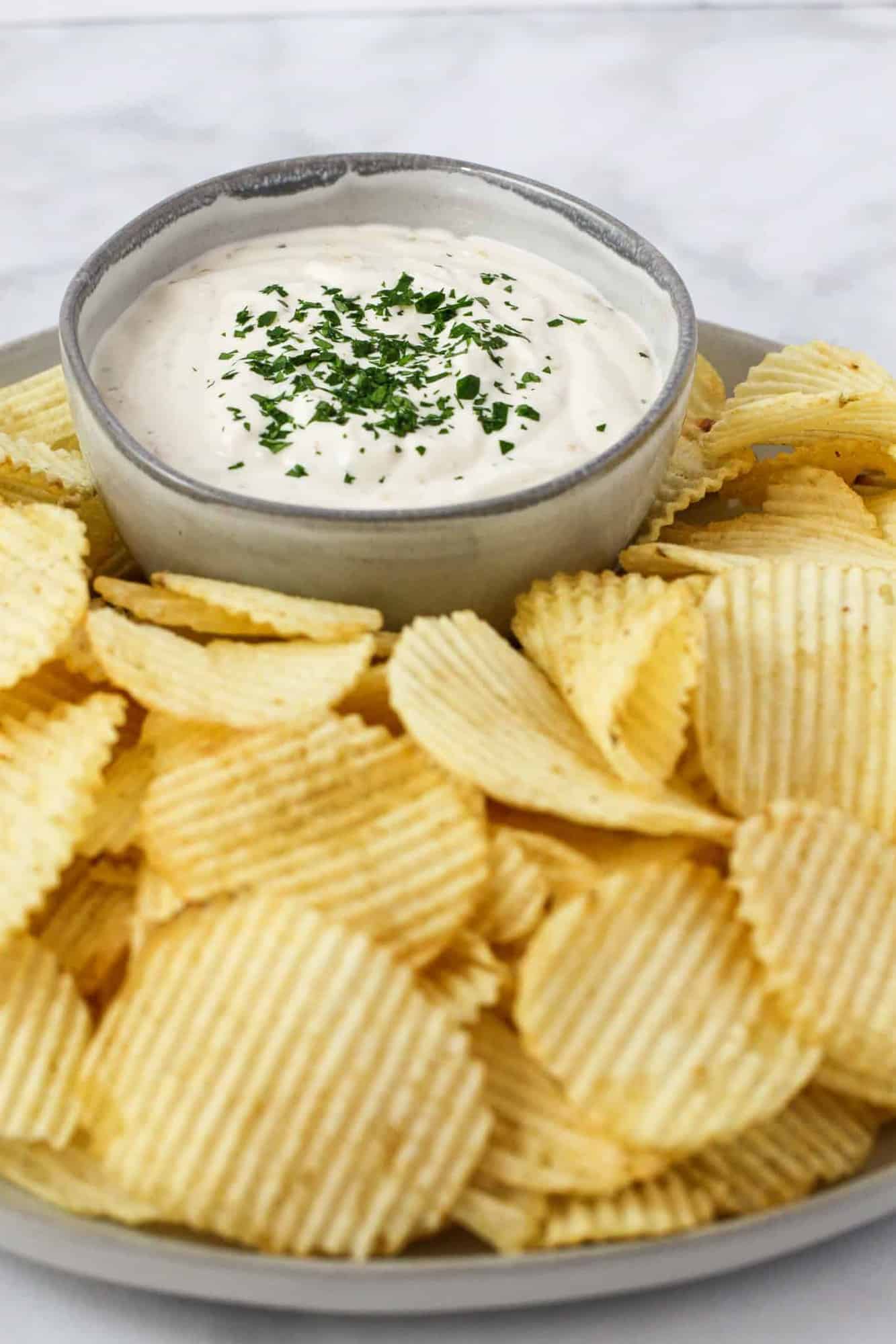 Sour Cream and Onion Dip shown served on a platter with potato chips.