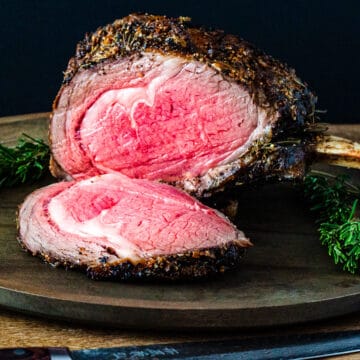 A standing rib roast shown on a platter with a slice carved off and set in front.