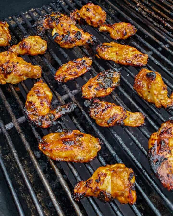 Chicken wings being cooked on a grill.