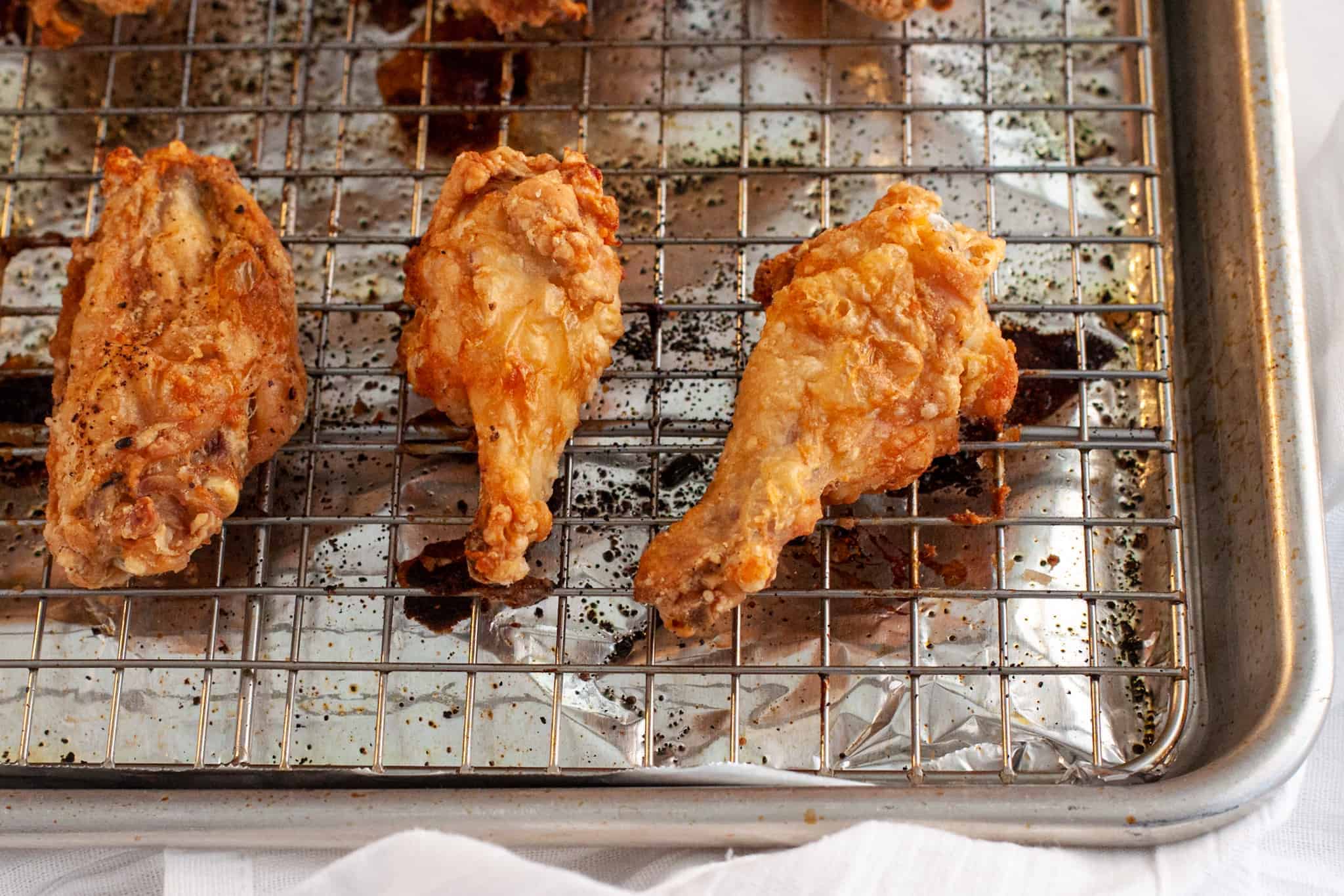 Crispy chicken wings shown after being baked on a sheet pan.