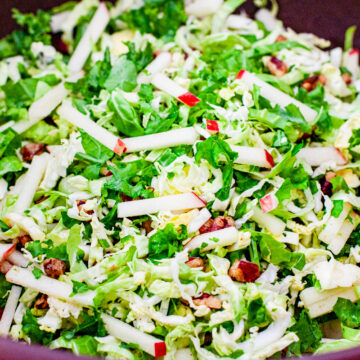 Shaved brussels sprouts and kale salad in a serving bowl.