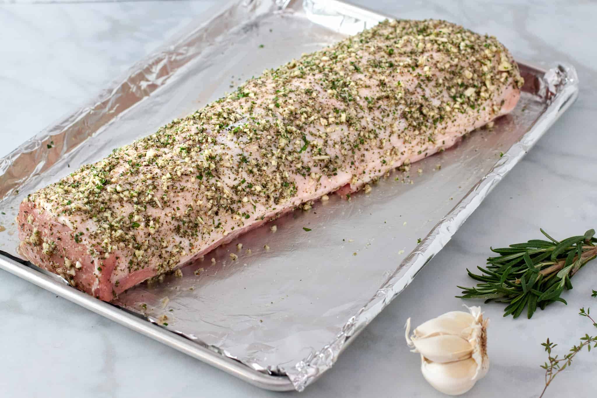 In this picture the pork loin is coated with a layer of the herb mixture before roasting. 
