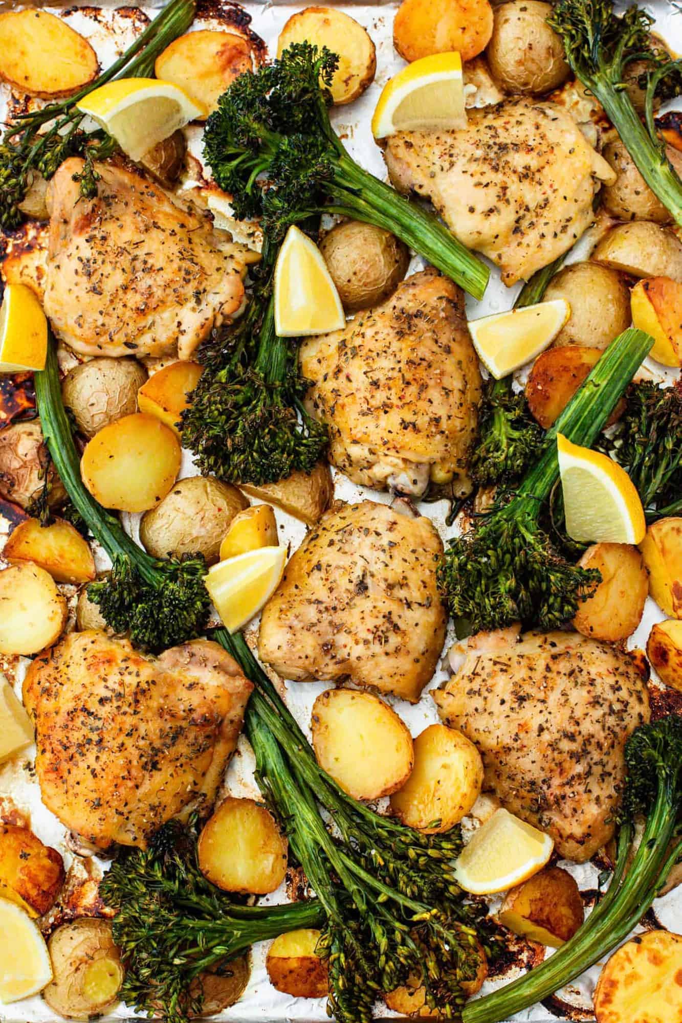 A sheet pan of lemon garlic chicken with potatoes and broccoli.