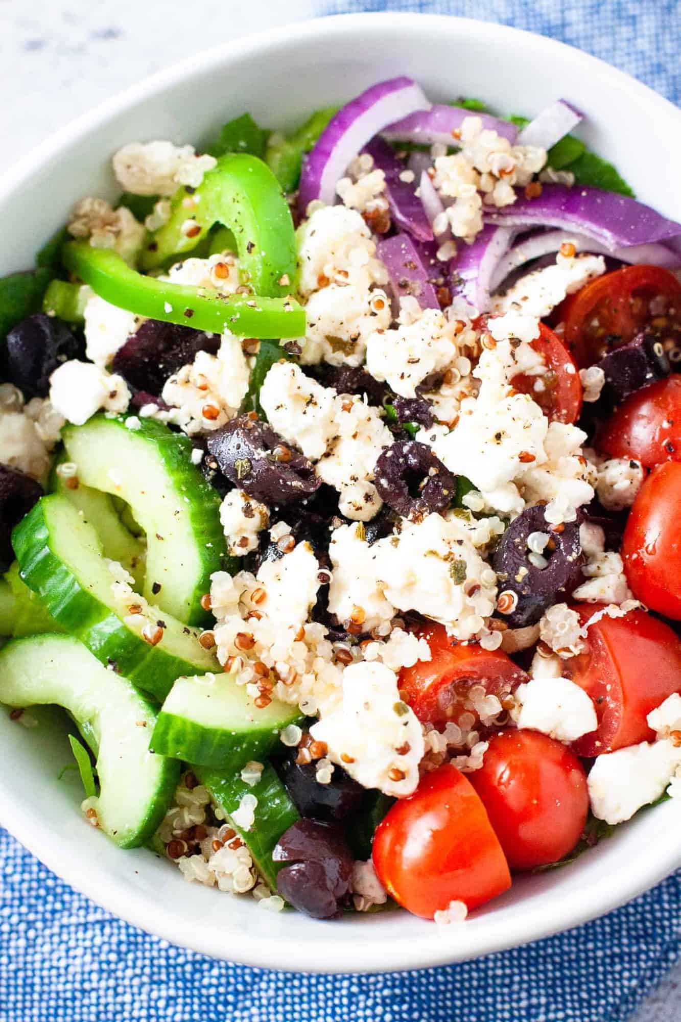 Close up overhead image of a bowl full of quinoa Greek salad.