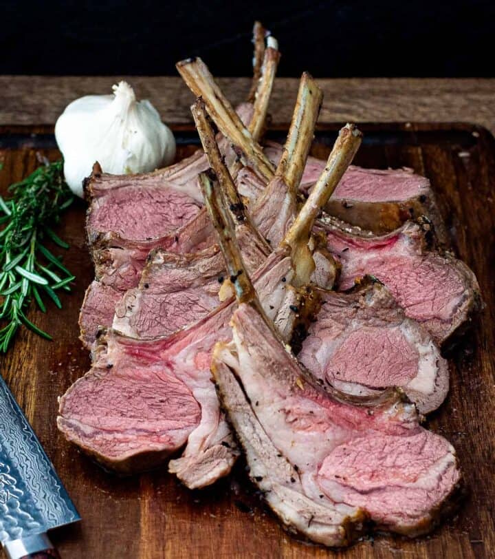 sliced Garlic and Herb Crusted Rack of Lamb on cutting board