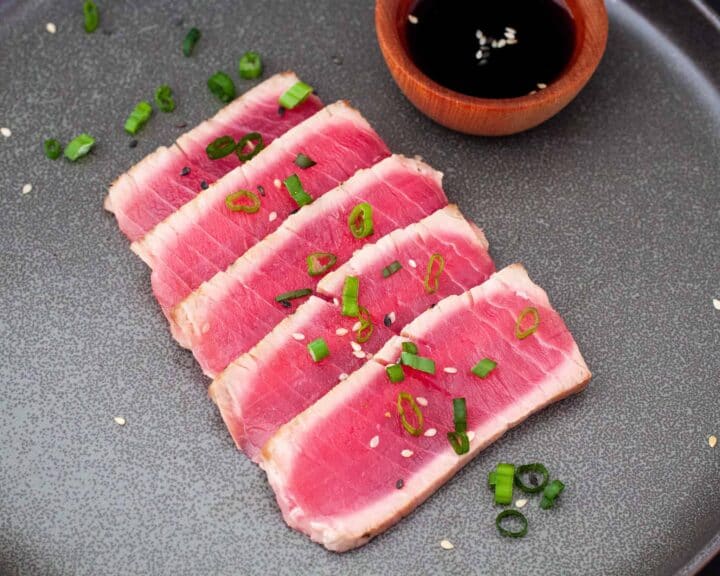 Sliced seared tuna shown on a plate.