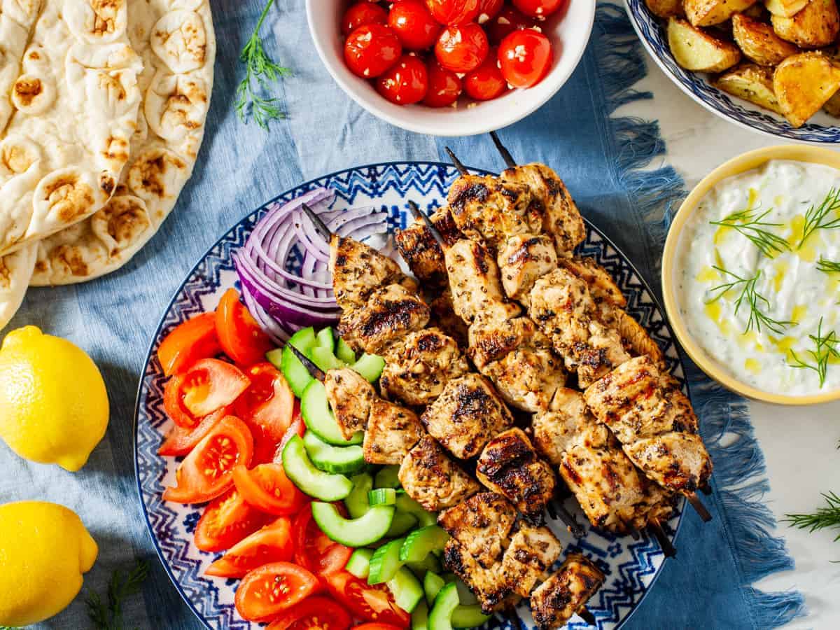 chicken souvlaki platter on table with sides