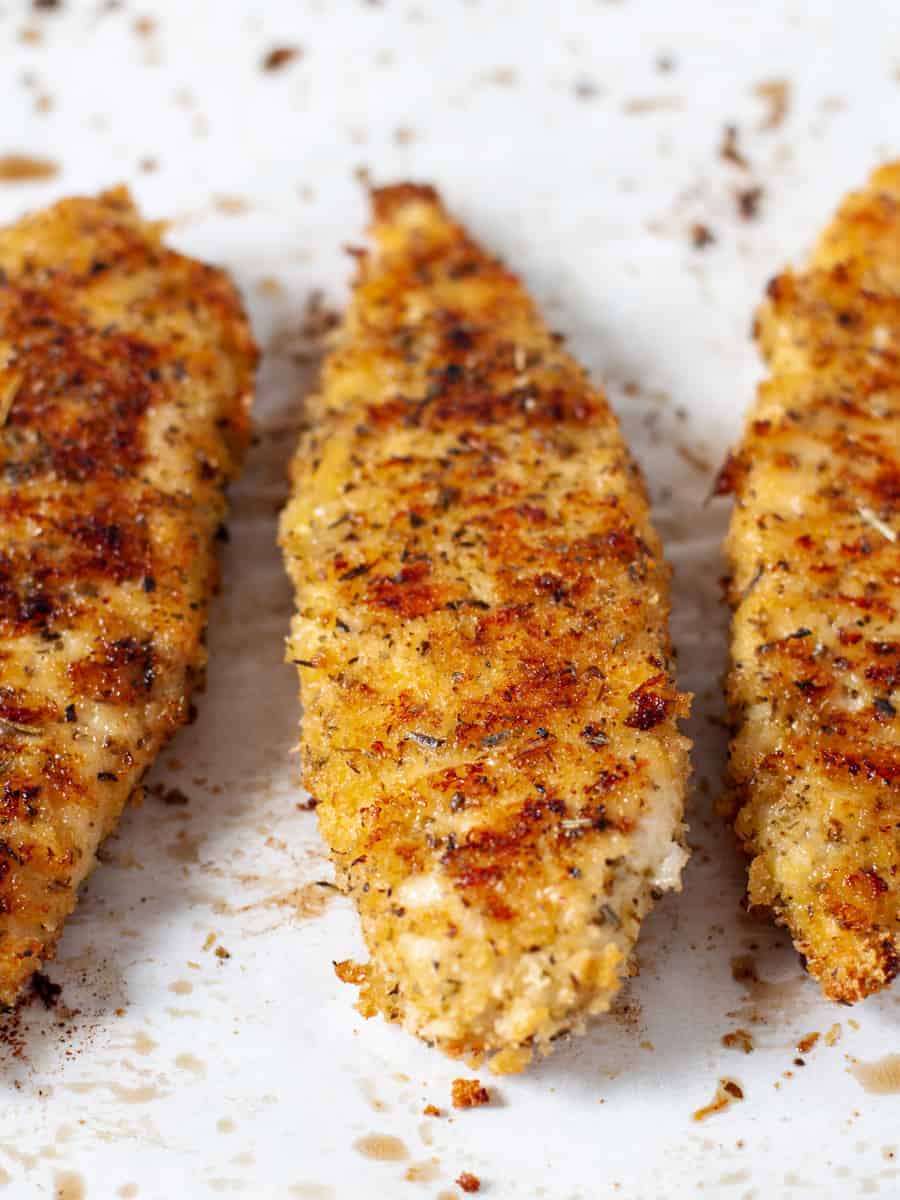 Close up of cooked panko chicken tenders on a sheet pan.