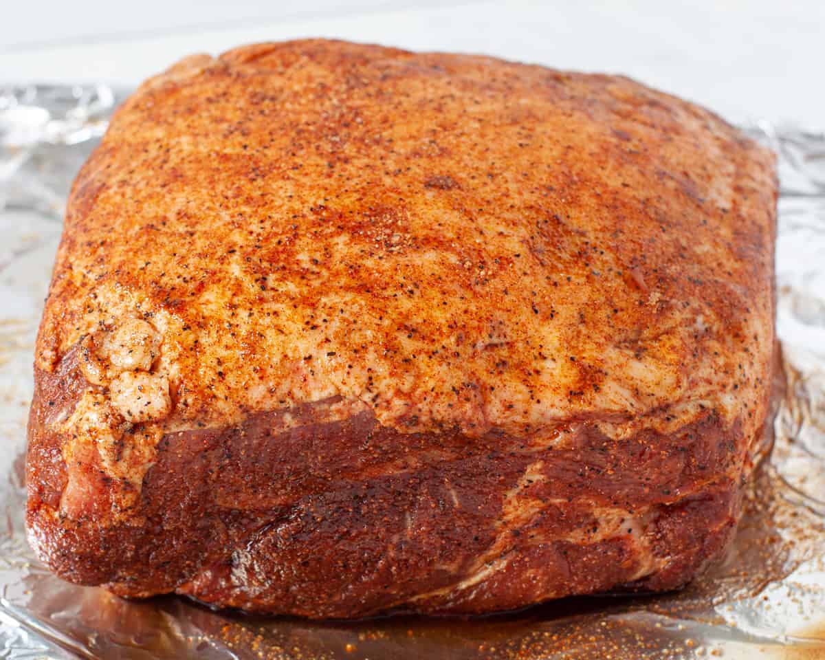 Seasoned pork shoulder shown prior to cooking.