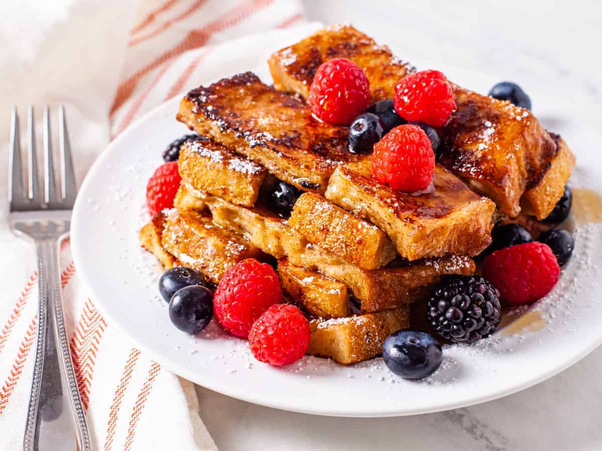 French toast sticks topped with maple syrup and fresh berries