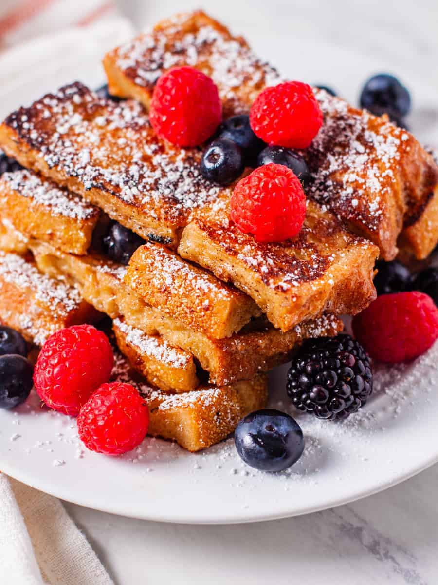 French toast sticks topped with powdered sugar and berries