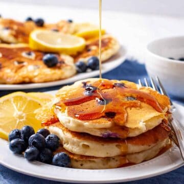 Lemon Blueberry pancakes shown with a drizzle of maple syrup