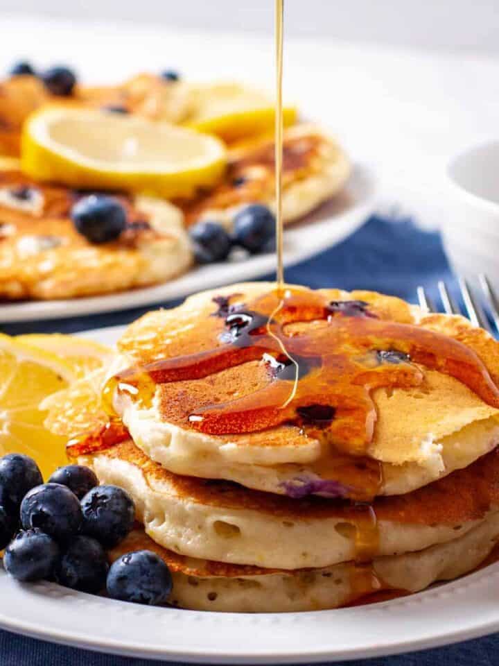 Lemon Blueberry pancakes shown with a drizzle of maple syrup