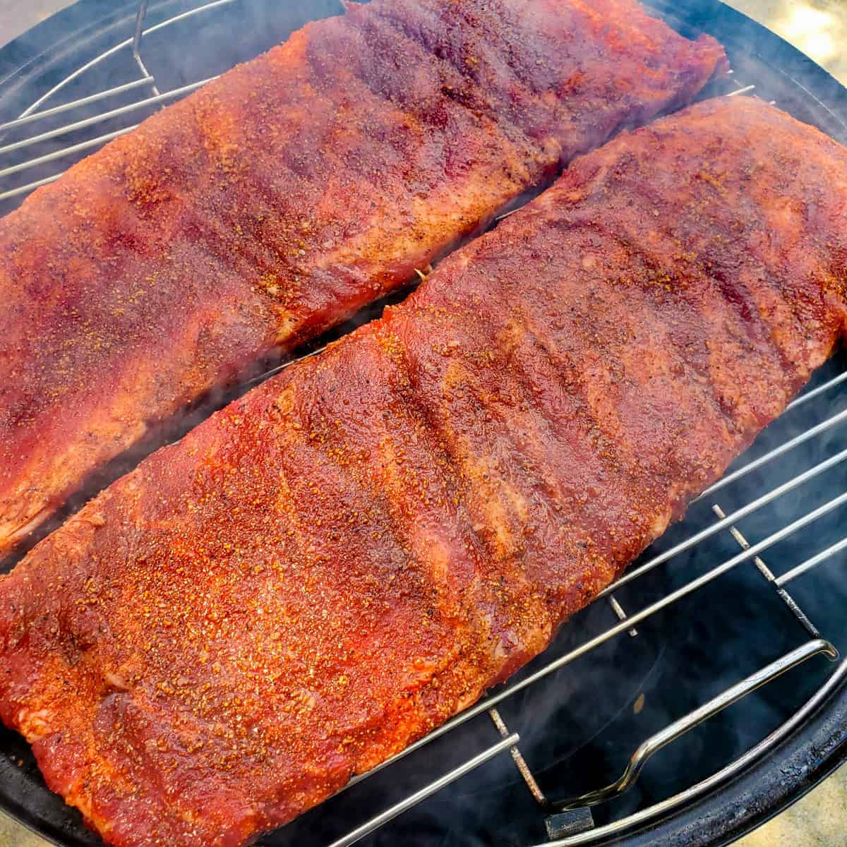 St Lousi cut spare ribs shown on a smoker at the start of cooking