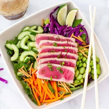 Overhead view of a salad topped with sliced tuna.