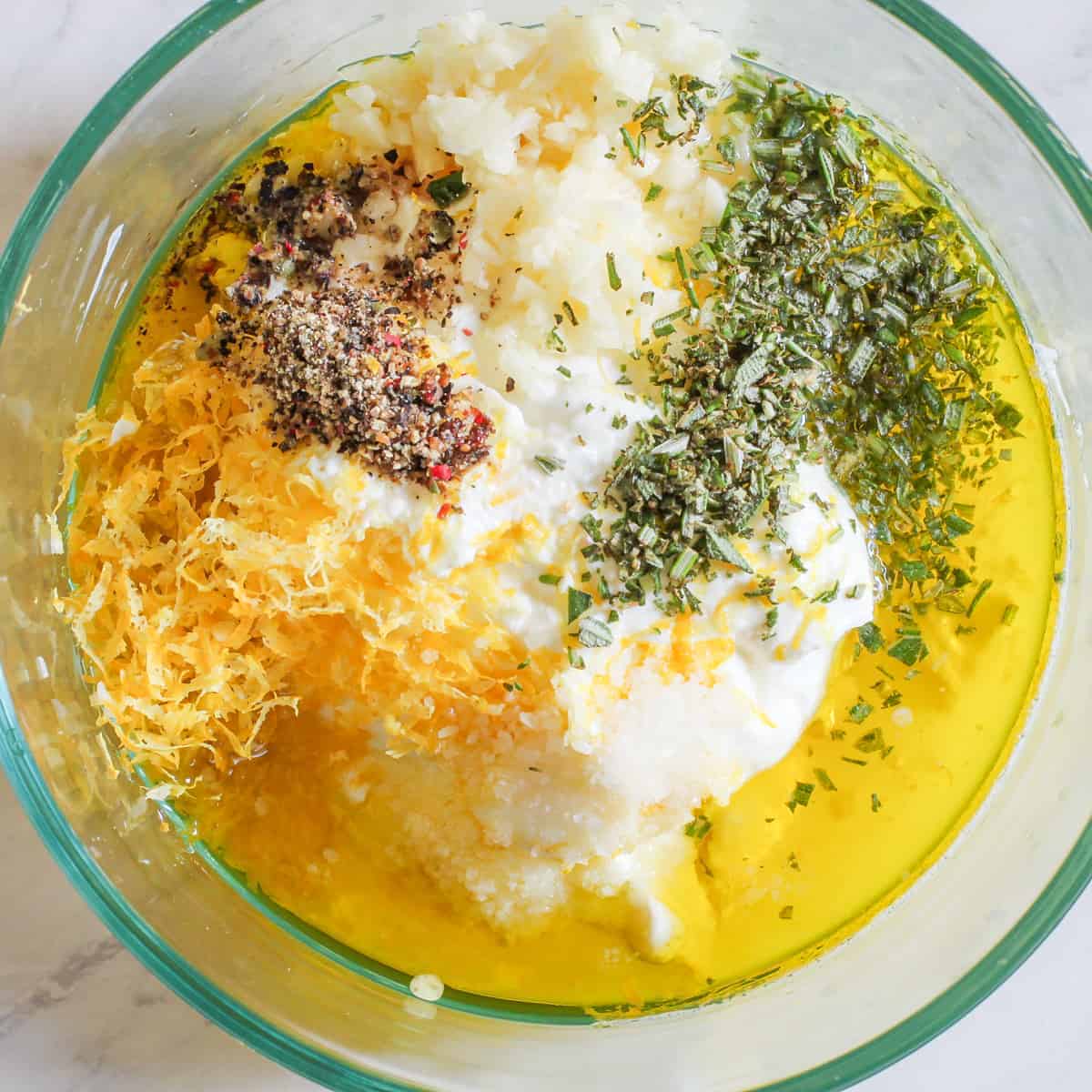 Ingredients for the Greek yogurt marinade are shown in a mixing bowl.