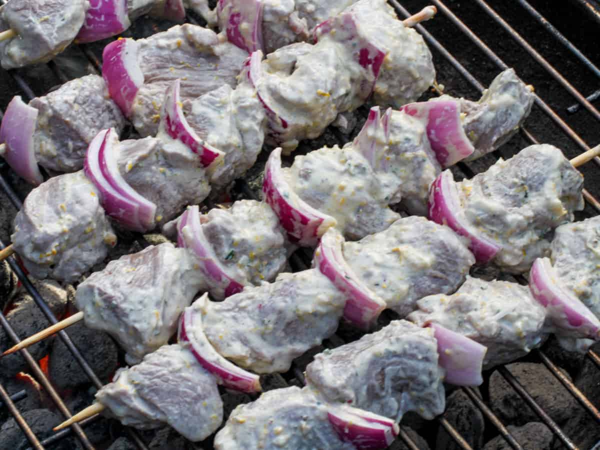 Marinated lamb kebabs cooking on a hot grill.