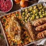A sheet pan of roasted turkey and stuffing with vegetables.
