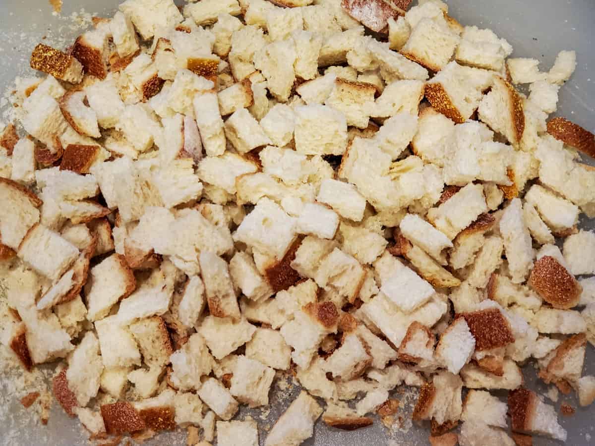 Homemade bread cubes shown on a cutting board.