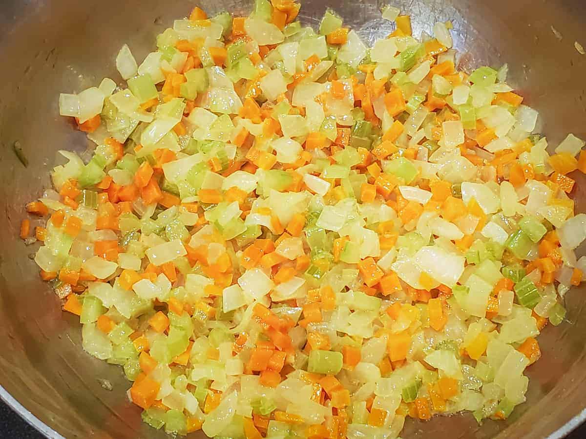 The diced vegetables are sauteed in butter until softened.