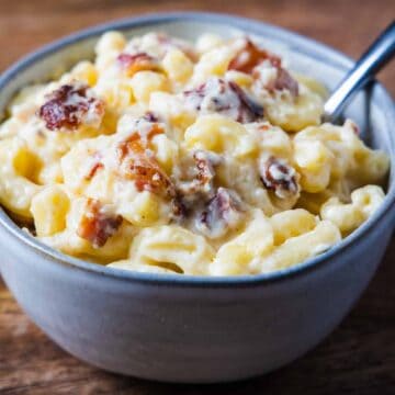 Side angle view of a small bowl of creamy bacon mac and cheese.