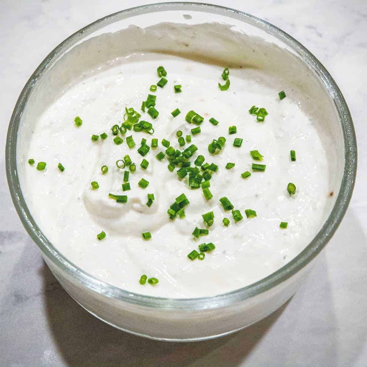 A bowl of horseradish cream sauce topped with chives.