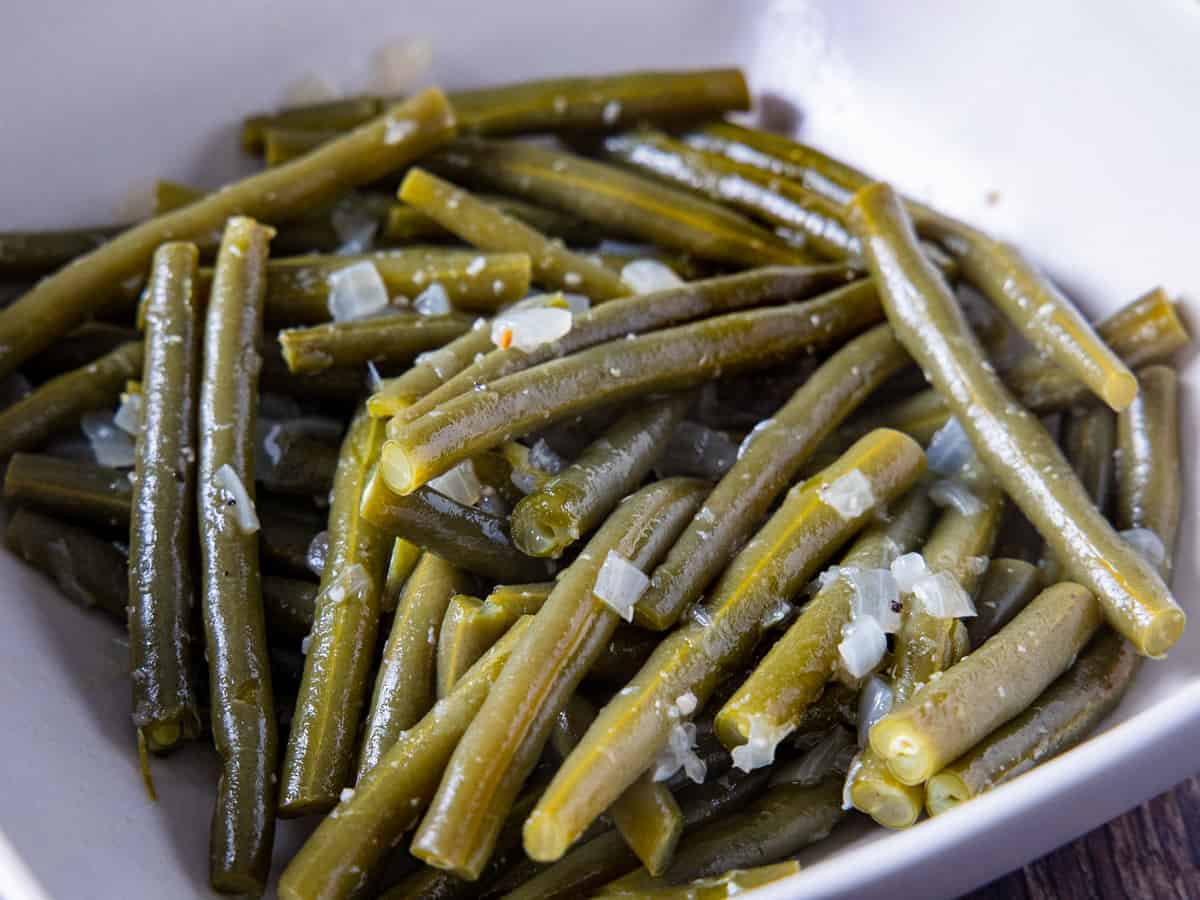 the finished Southern style green beans are shown in a large serving bowl.