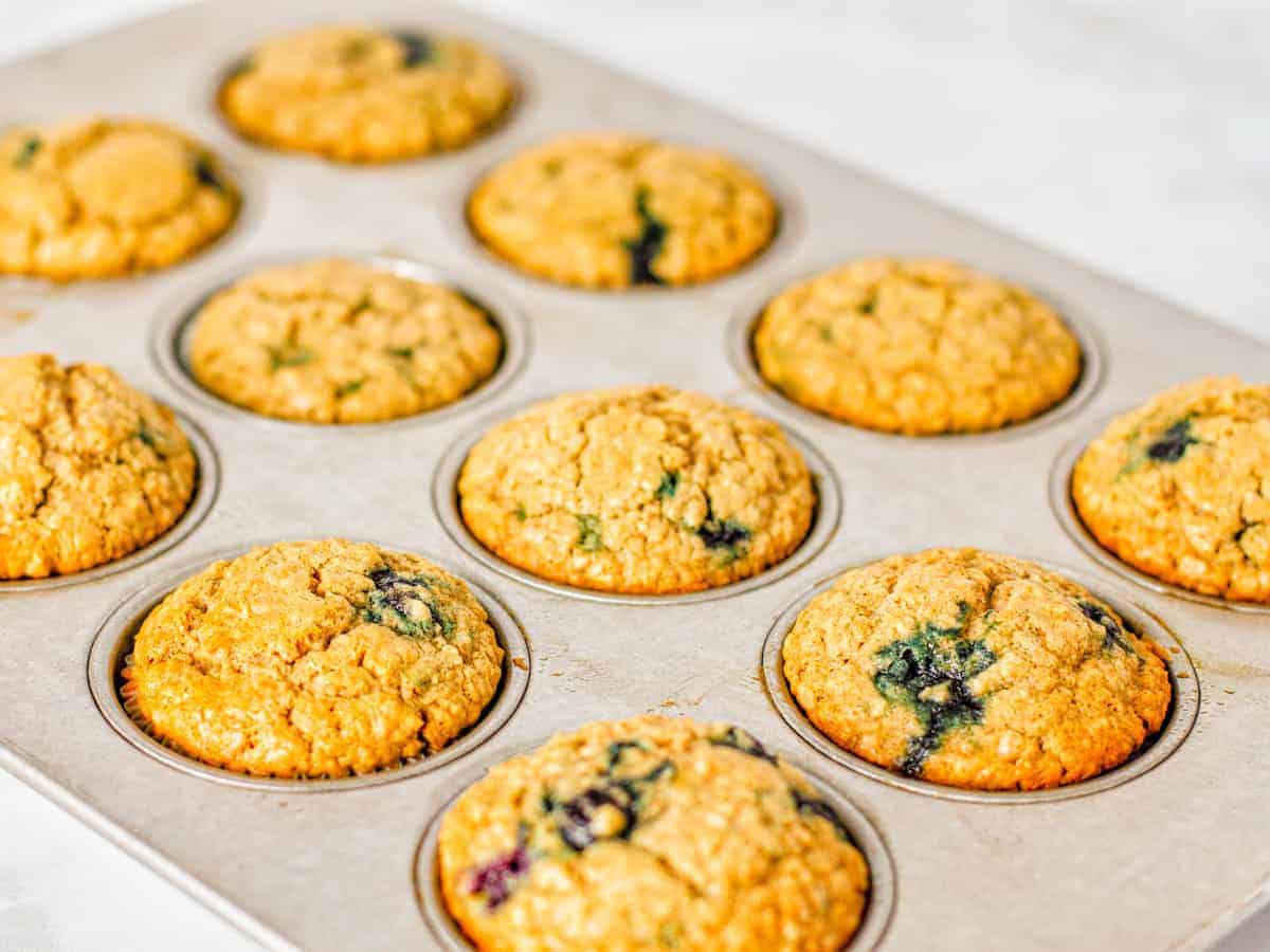 The finished oatmeal blueberry muffins are shown in the baking pan. 