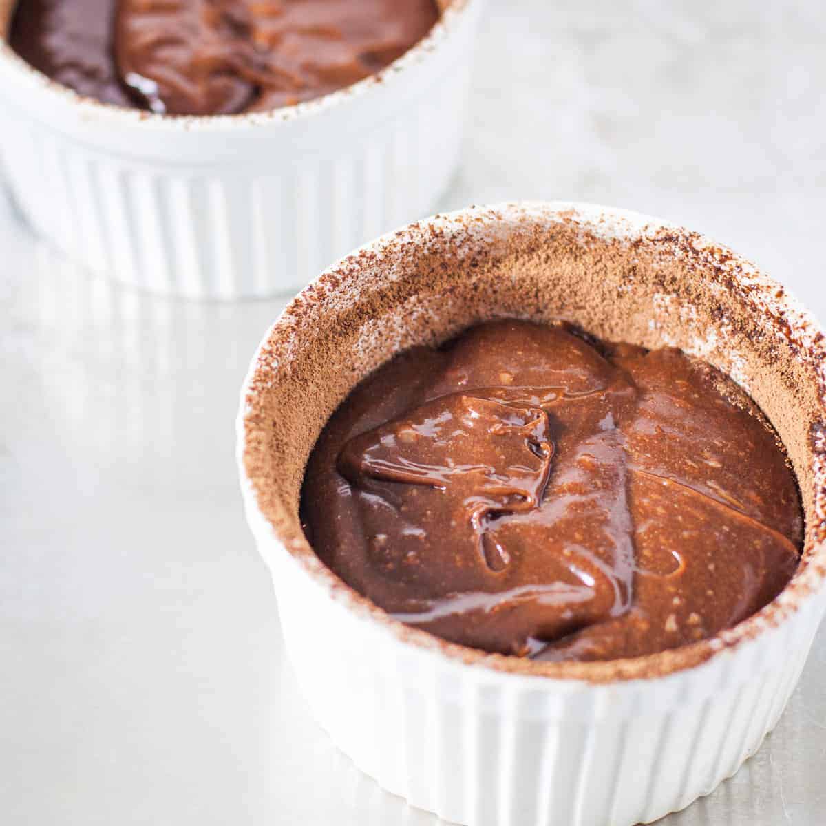 Molten chocolate lava cake batter shown in a prepared ramekin before baking.