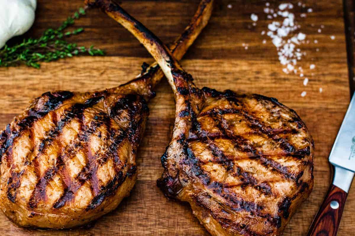 Grilled pork chops shown on a cutting board.