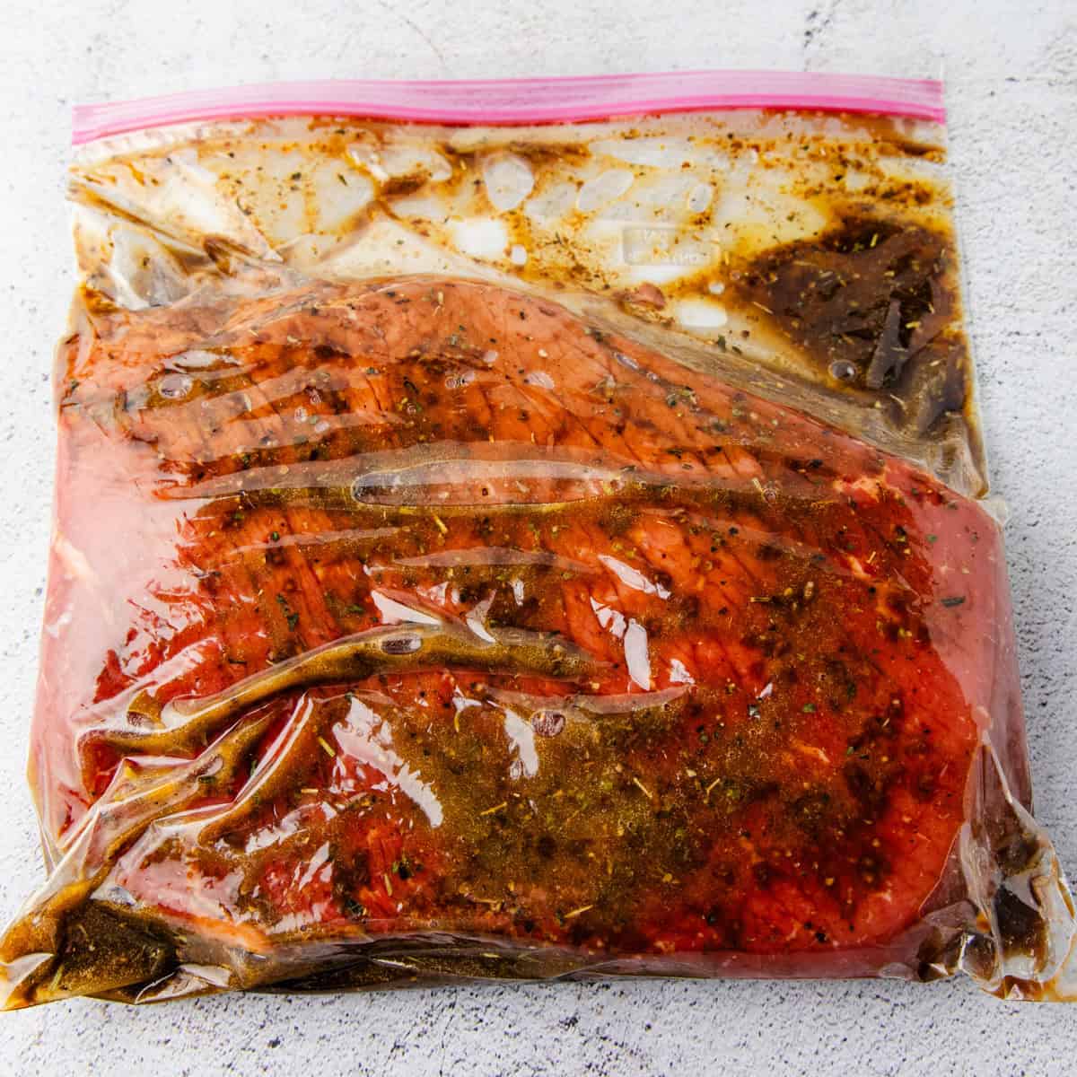 Beef being marinated in a bag.