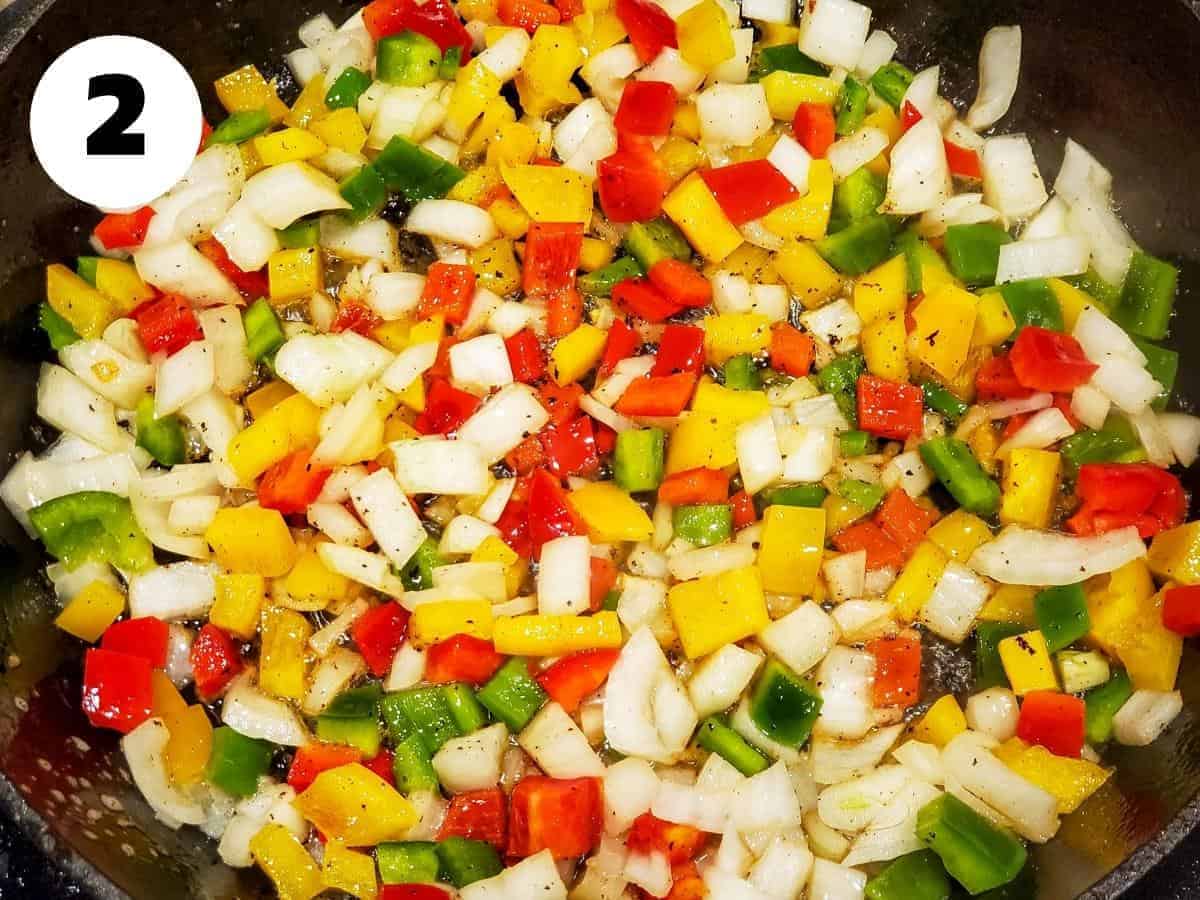 Onions and peppers cooking in a skillet.