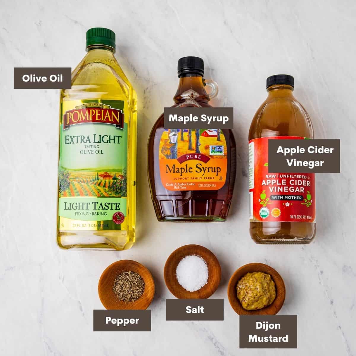 Ingredients for maple vinaigrette dressing shown arranged on a counter.