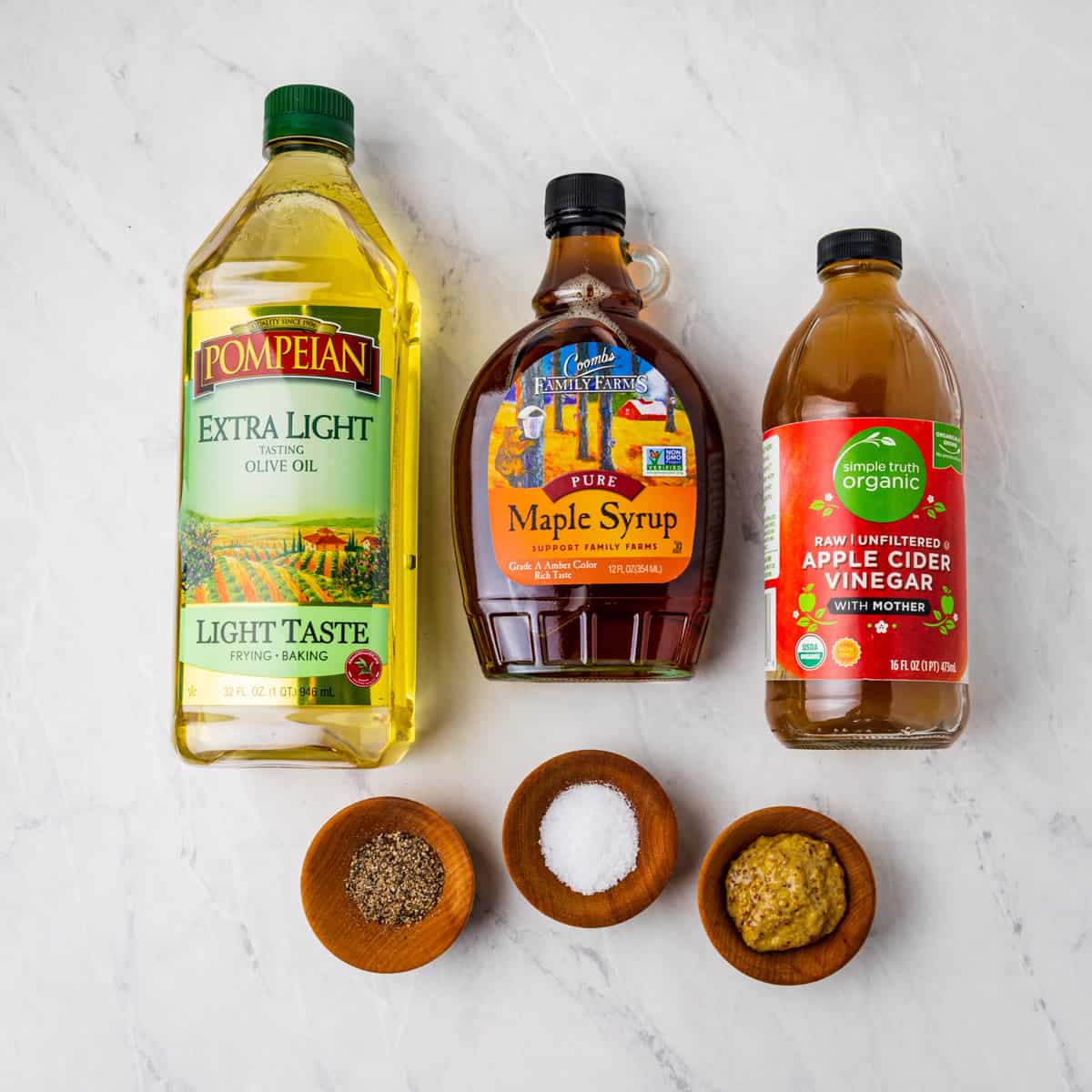 Ingredients for maple vinaigrette dressing shown set on a counter.