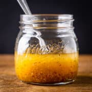Side angle view of a jar of maple vinaigrette dressing.