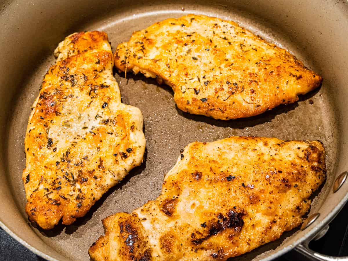 Cooked chicken breasts in a skillet.
