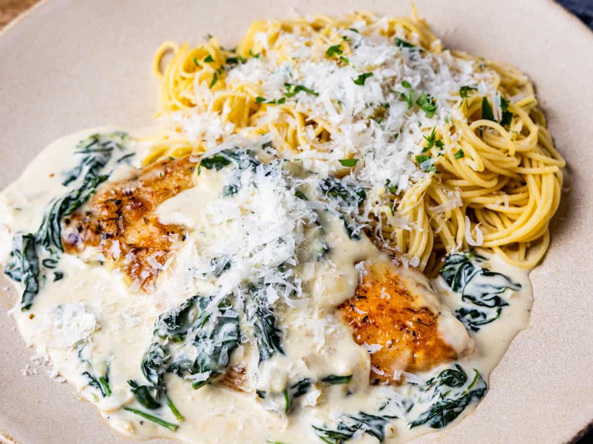 Chicken Florentine shown on a plate served with pasta noodles.