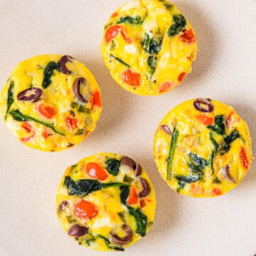 Egg bites with spinach, feta, and veggies served on a plate.