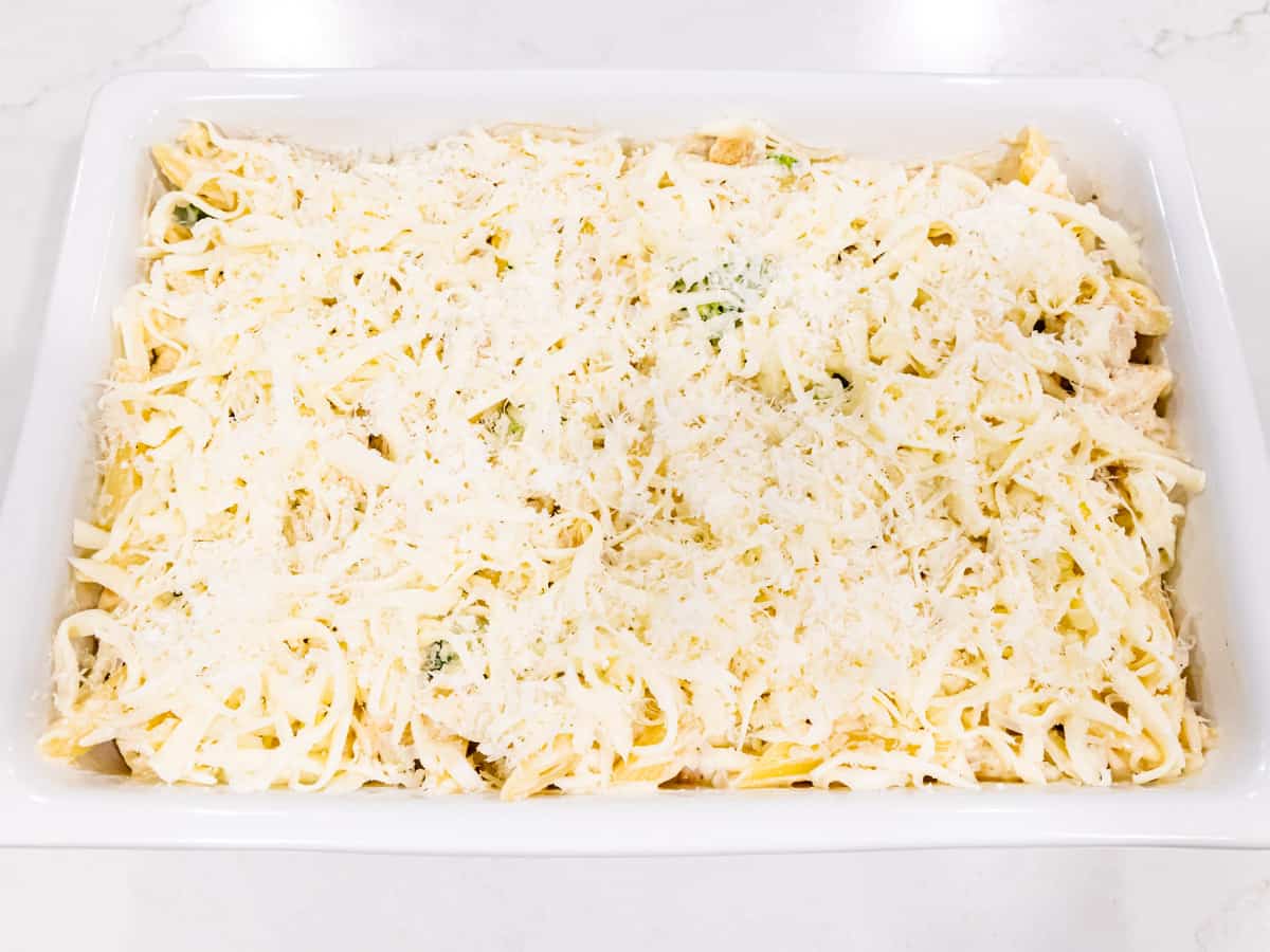 The assembled pasta casserole is shown after being topped with shredded cheese.