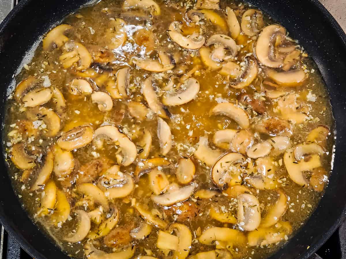 Sauce for chicken marsala shown cooking in a skillet.