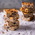 Homemade chocolate cherry granola bars stacked on a table.