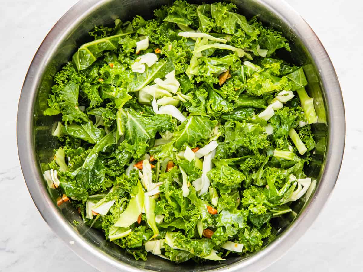 Kale salad shown in a mixing bowl after combining the ingredients.