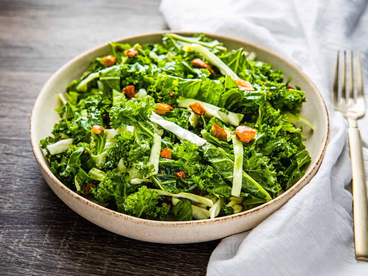 A bowl of kale crunch salad set on a table.