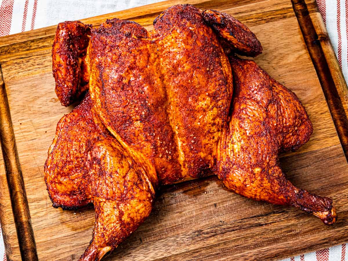 Smoked whole chicken shown on a cutting board