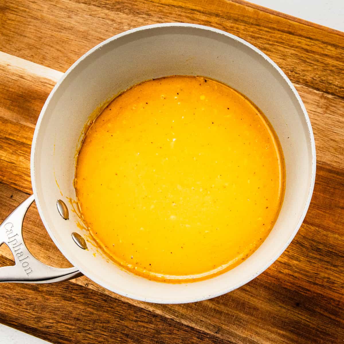 A small saucepan filled withCarolina gold BBQ sauce.