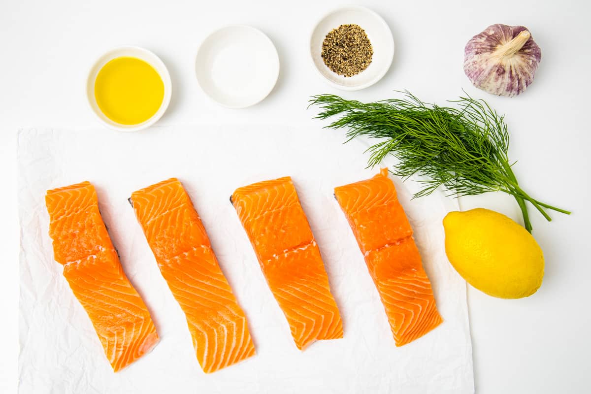 Ingredients for lemon dill baked salmon shown set on a counter.