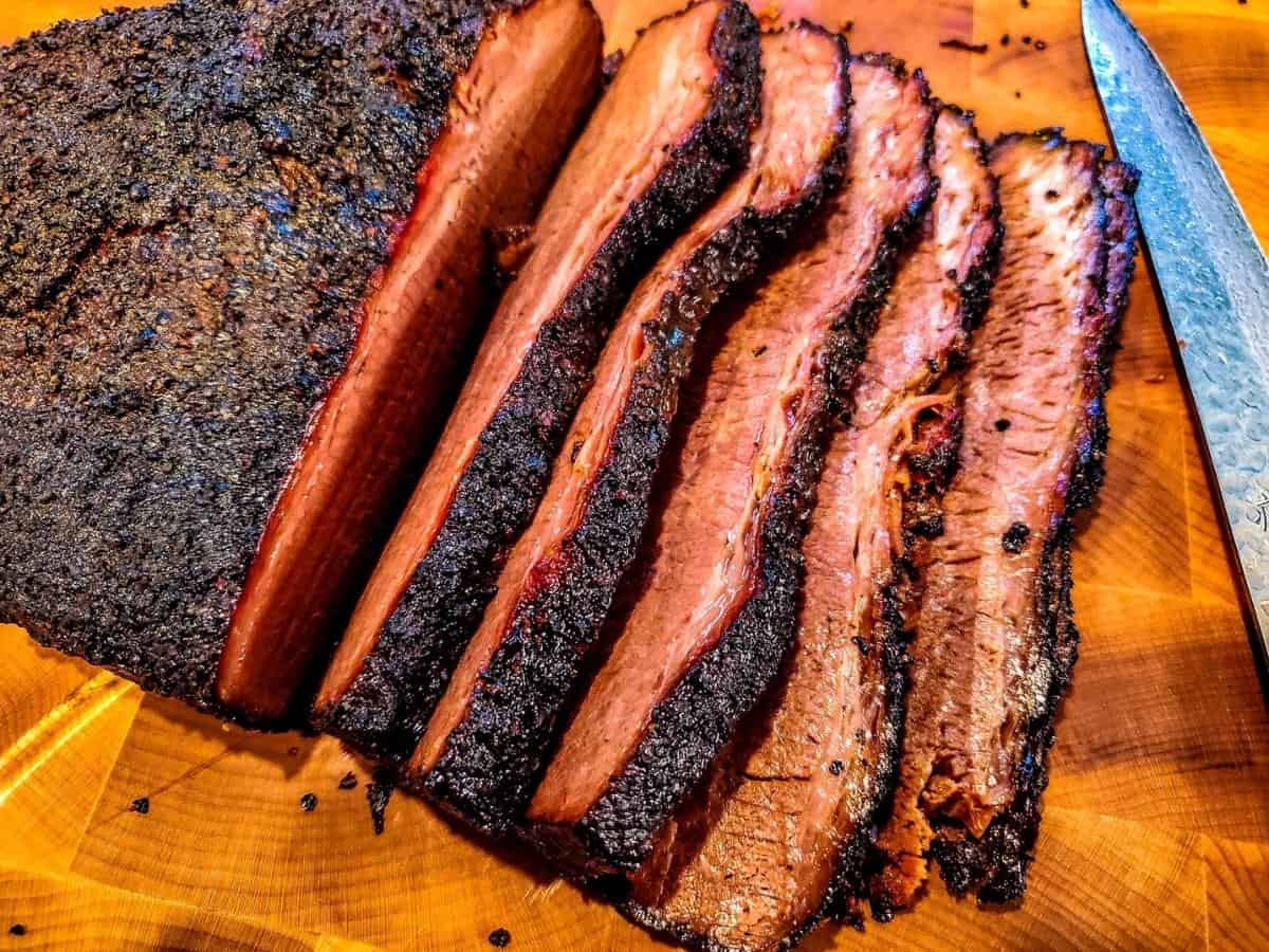 Sliced smoked brisket on a cutting board. 